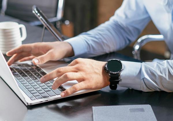 A person typing on a laptop at a desk