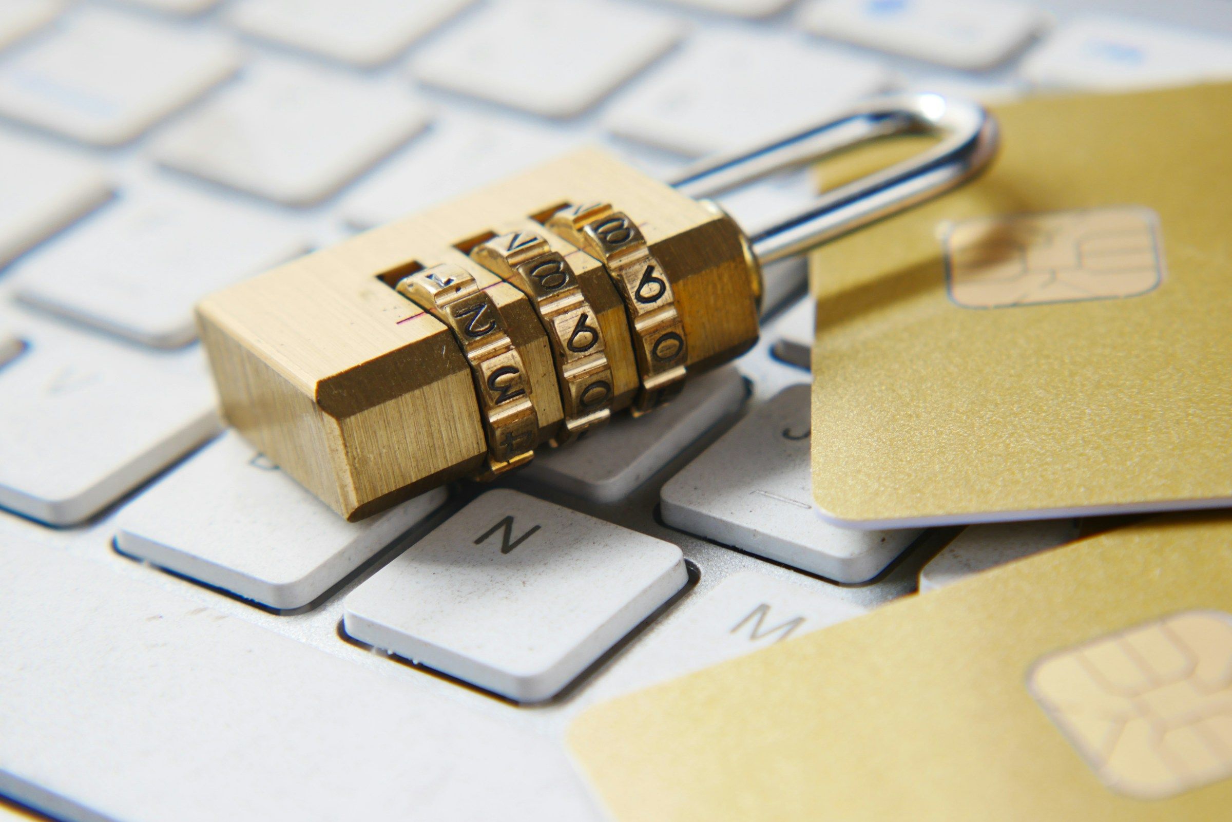 A padlock resting on a keyboard beside chip payment cards
